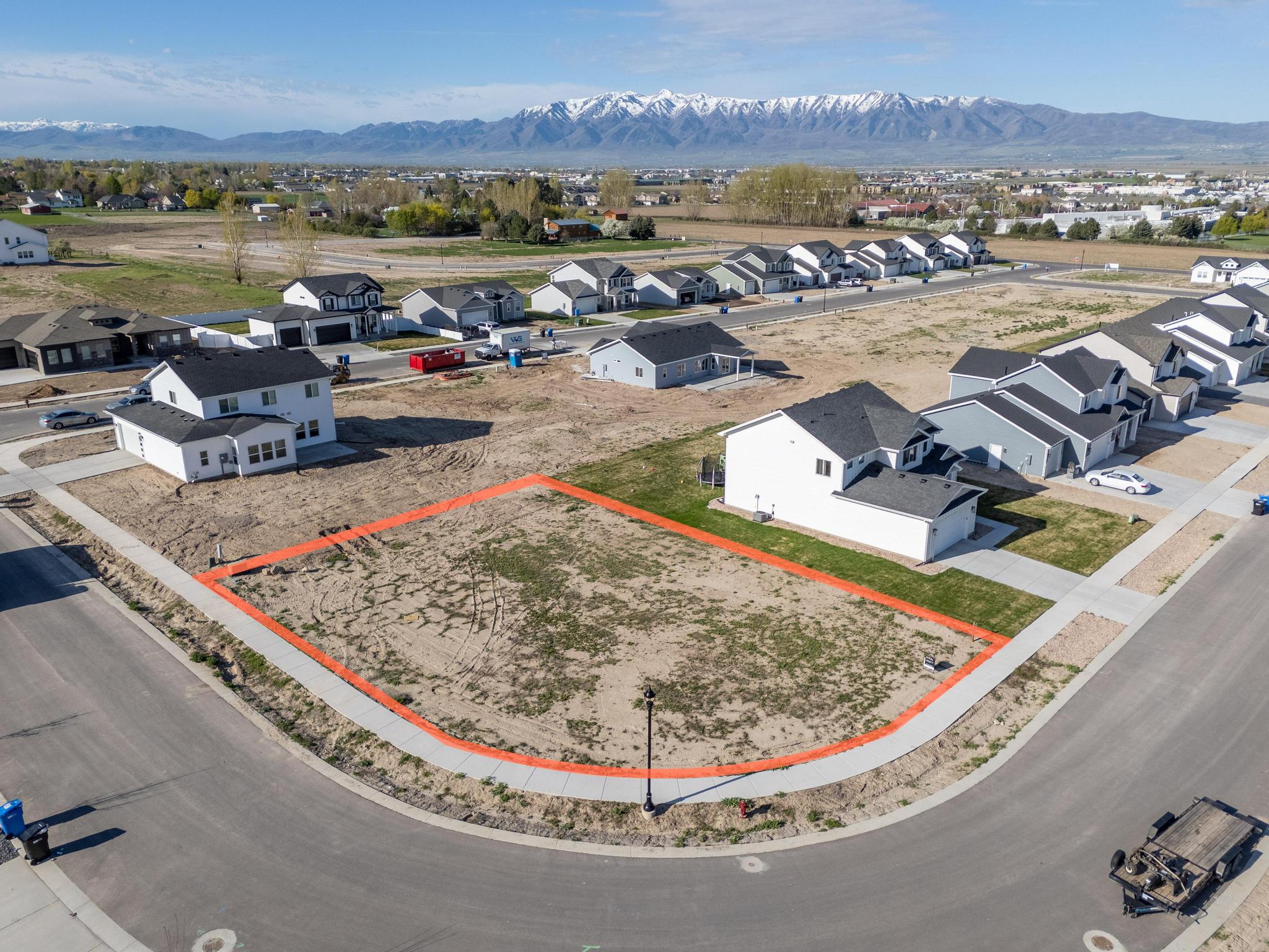 Aerial view of residential area featuring a mountainous background and property parcel outlined
