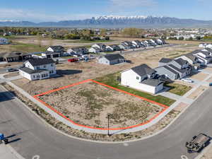Aerial view of residential area featuring a mountainous background and property parcel outlined
