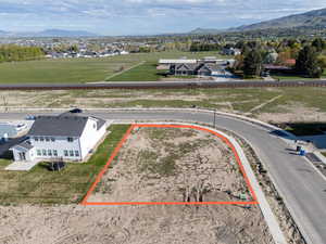 Aerial view of residential area featuring property boundaries highlighted and mountains