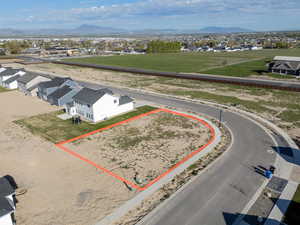 Aerial perspective of suburban area featuring property boundaries highlighted and a mountainous background