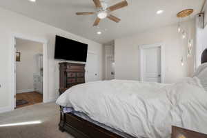 Bedroom with dark carpet, connected bathroom, ceiling fan, and recessed lighting