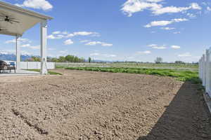 View of yard with ceiling fan, a patio area, a rural view, and a mountain view
