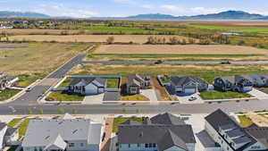 Aerial view of sparsely populated area with nearby suburban area, mountains, and extensive farmland