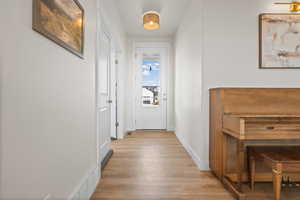 Hall with light wood-style floors and baseboards