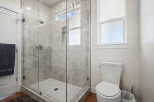 Full bathroom with a shower stall and wood finished floors