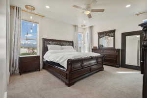 Bedroom with light carpet, a ceiling fan, and recessed lighting
