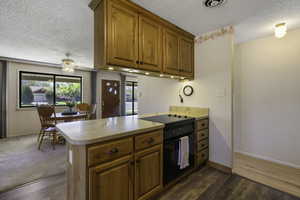 Kitchen with a peninsula,  light countertops, oven, and wood finish cabinetry