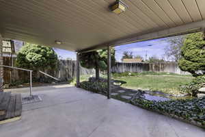 Fenced backyard with a covered patio