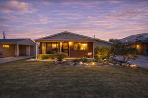 Ranch-style house featuring a lawn, brick siding, and a patio