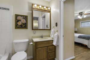 Full bath with vanity, ensuite bathroom, ceiling fan, light wood-style flooring