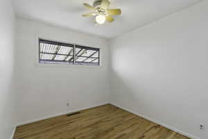 Empty room with light wood-style flooring and ceiling fan