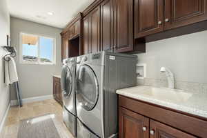 Laundry area featuring cabinet space, washing machine and dryer, and recessed lighting