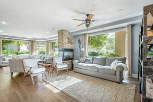 Living area featuring ceiling fan, hardwood / wood-style flooring, ornamental molding, a fireplace, and recessed lighting