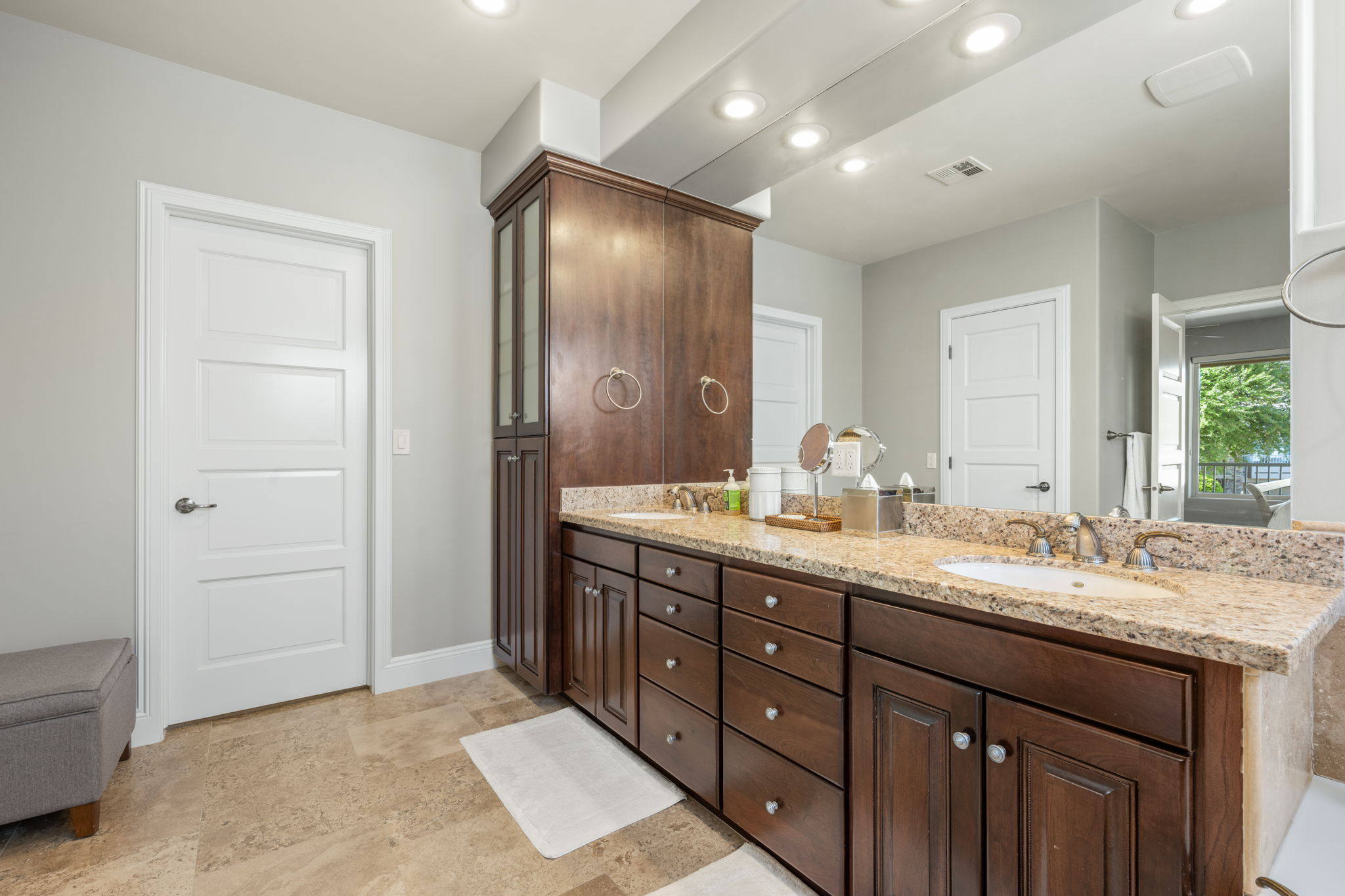 Full bath with double vanity, recessed lighting, and light stone finish floors