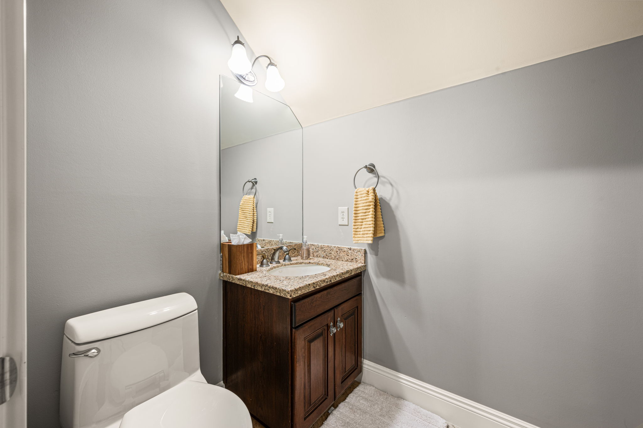 Half bathroom featuring vanity and toilet