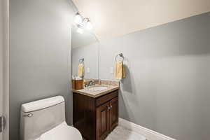 Half bathroom featuring vanity and toilet