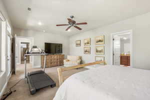 Bedroom with light colored carpet, ceiling fan, and ensuite bathroom