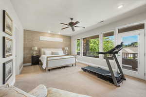 Bedroom featuring access to outside, light carpet, recessed lighting, an accent wall, and ceiling fan