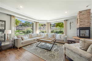 Living room with a fireplace, wood-type flooring, and recessed lighting