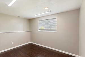 Spare room with dark wood-style floors and a textured ceiling