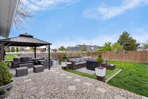 Fenced backyard with outdoor furniture, a patio, and a gazebo
