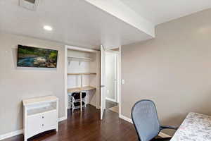 Office space featuring a textured ceiling and dark wood-type flooring