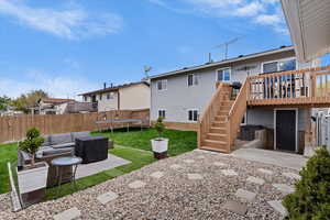 Back of house featuring outdoor seating, a patio area, a trampoline, and a fenced backyard