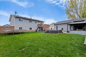 Rear view of house featuring a deck, an outdoor hangout area, a gazebo, a patio area, and a trampoline