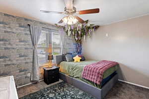 Bedroom with dark colored carpet, a ceiling fan, and a textured ceiling