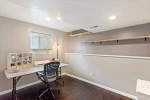 Home office with dark wood finished floors, a textured ceiling, and recessed lighting