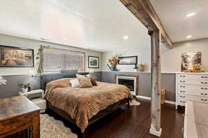 Bedroom featuring hardwood / wood-style floors, a textured ceiling, recessed lighting, and a fireplace