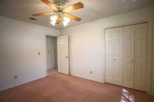 Unfurnished bedroom featuring carpet, a ceiling fan, and a closet