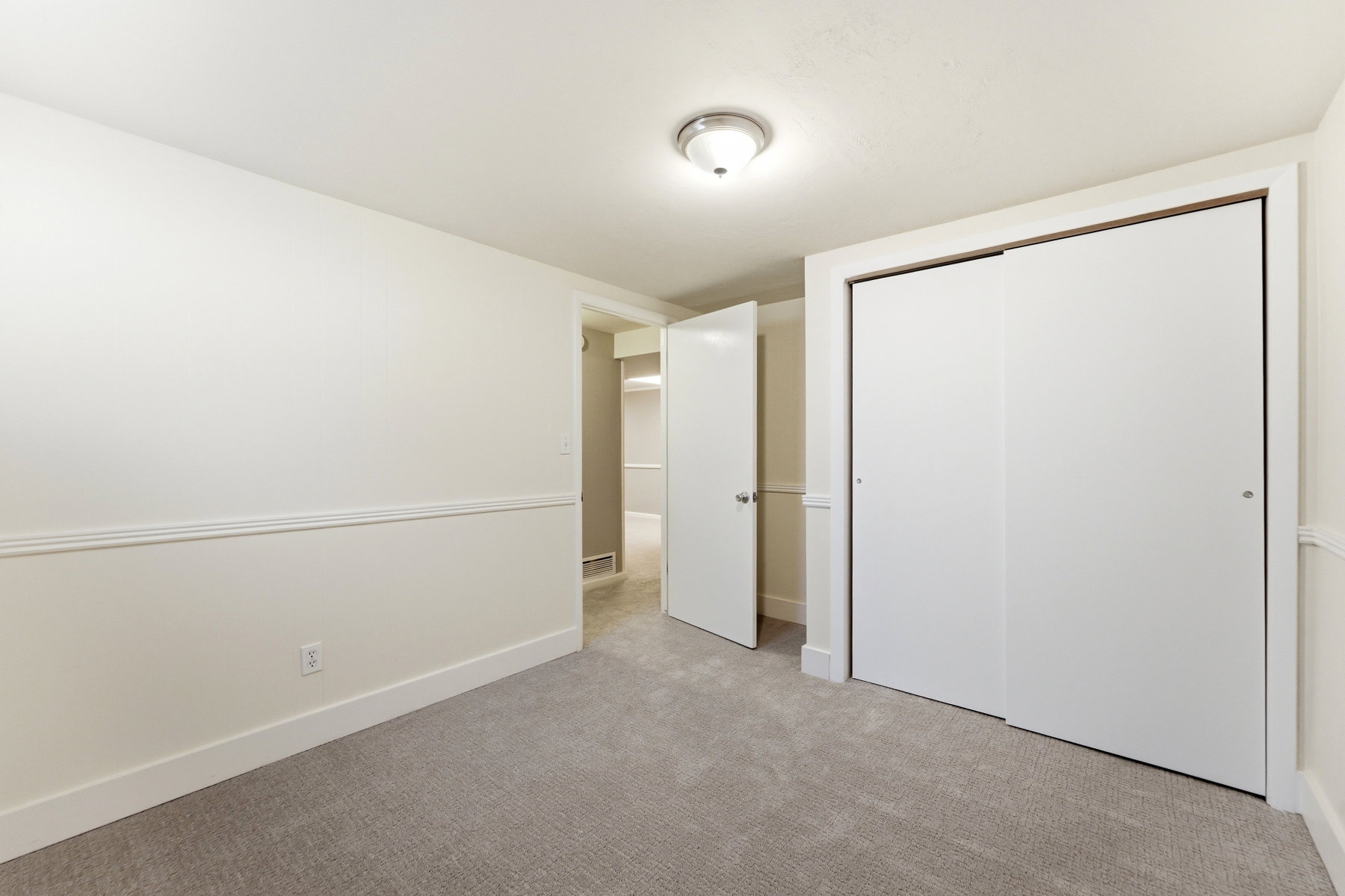 Unfurnished bedroom featuring light carpet and a closet