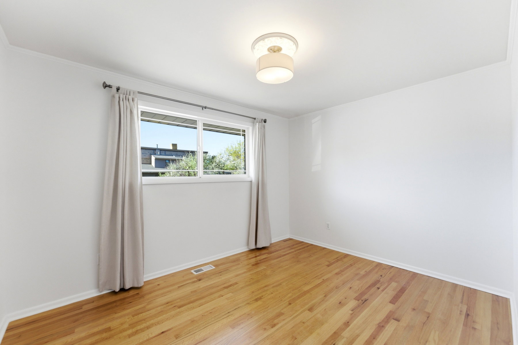 Spare room featuring light wood-style floors and baseboards
