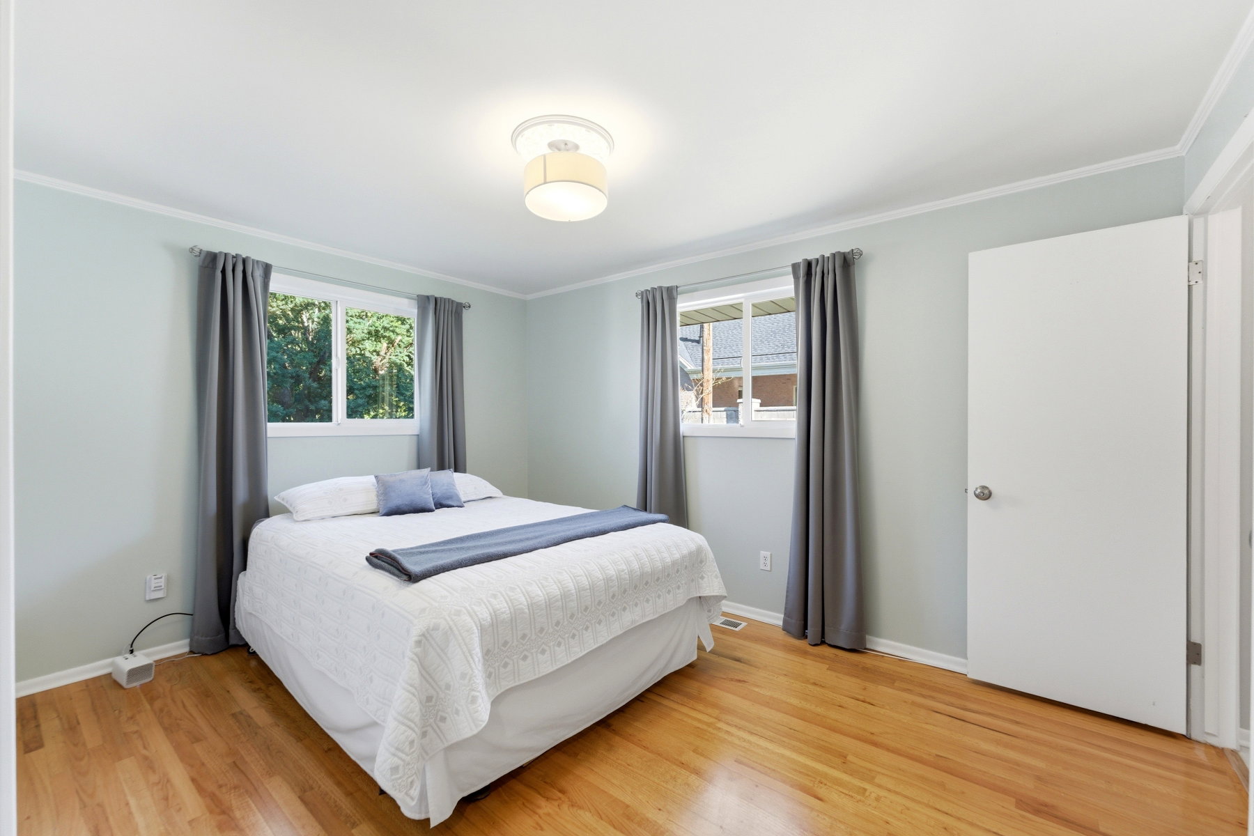 Bedroom with light wood-style floors and ornamental molding