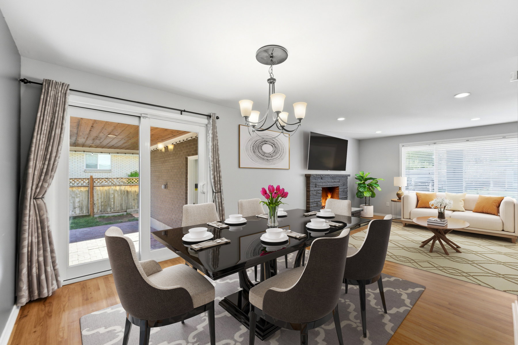 Dining area with a chandelier, a stone fireplace, and light wood-style floors