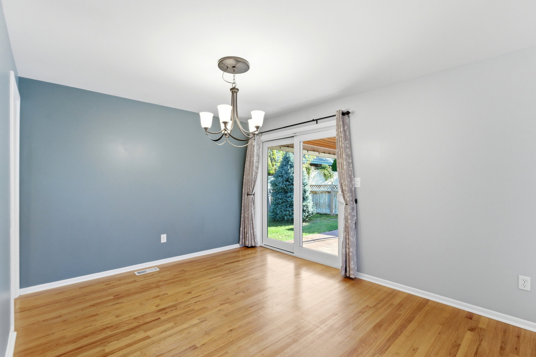 Spare room featuring light wood finished floors and suspended lighting