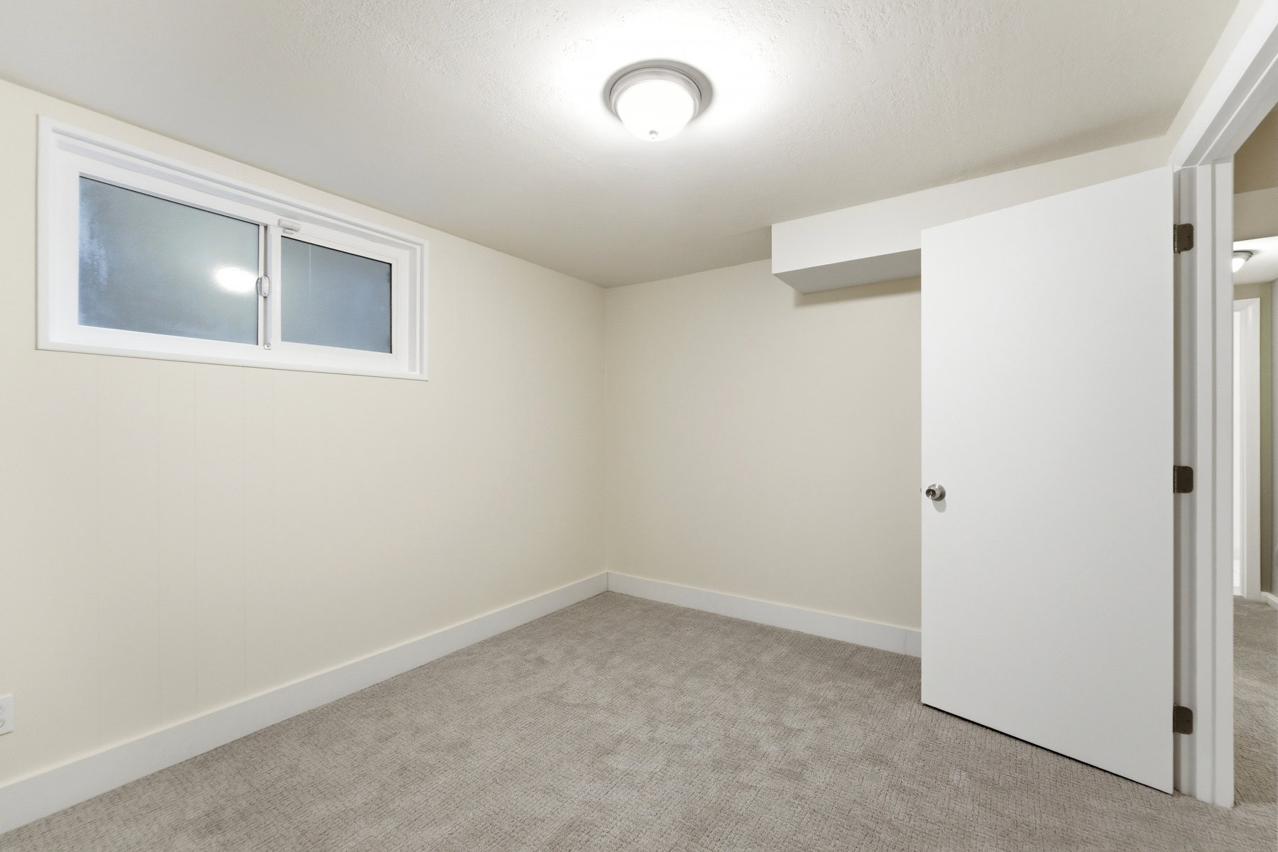 Unfurnished room featuring light carpet and baseboards