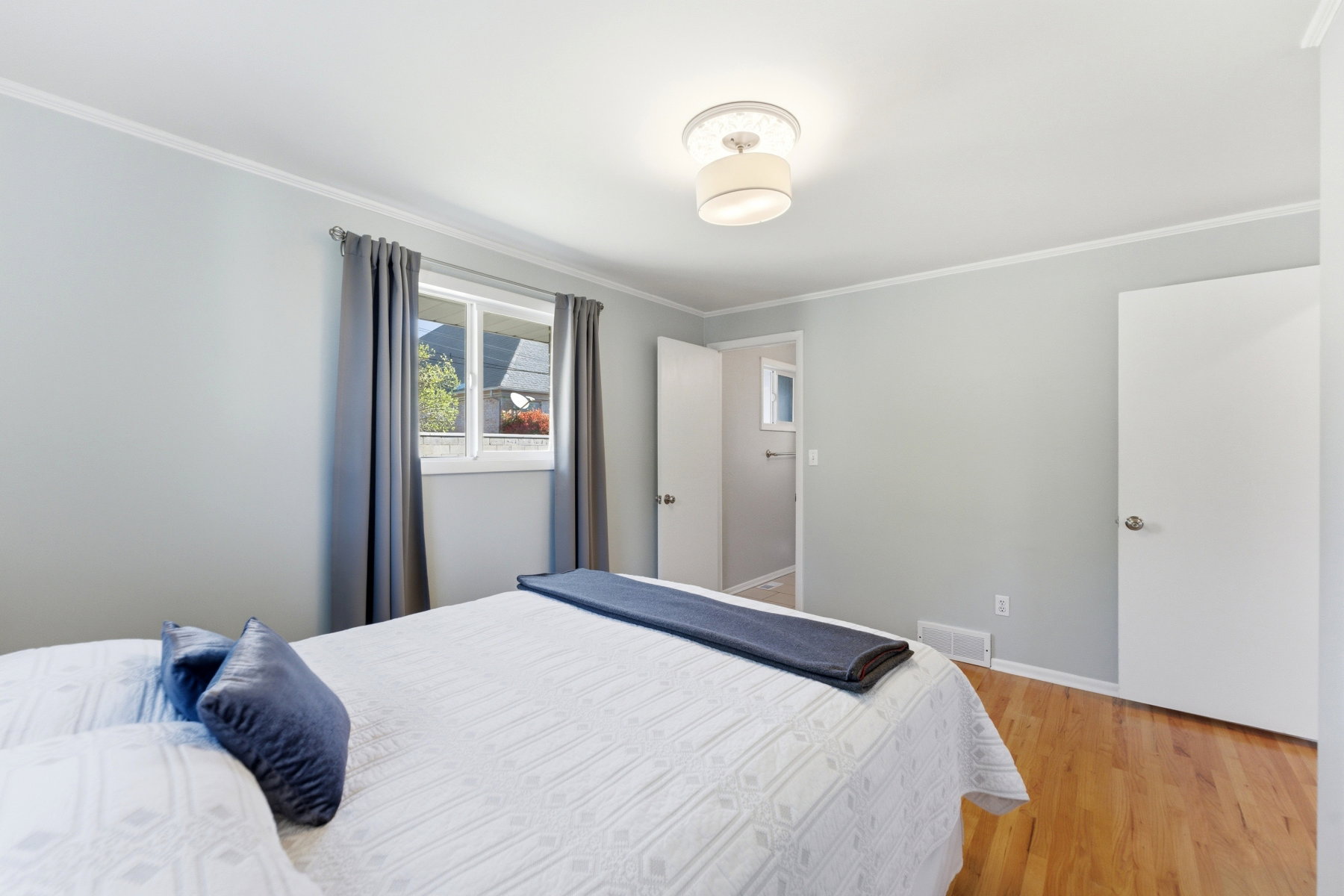 Bedroom with light wood-type flooring and ornamental molding