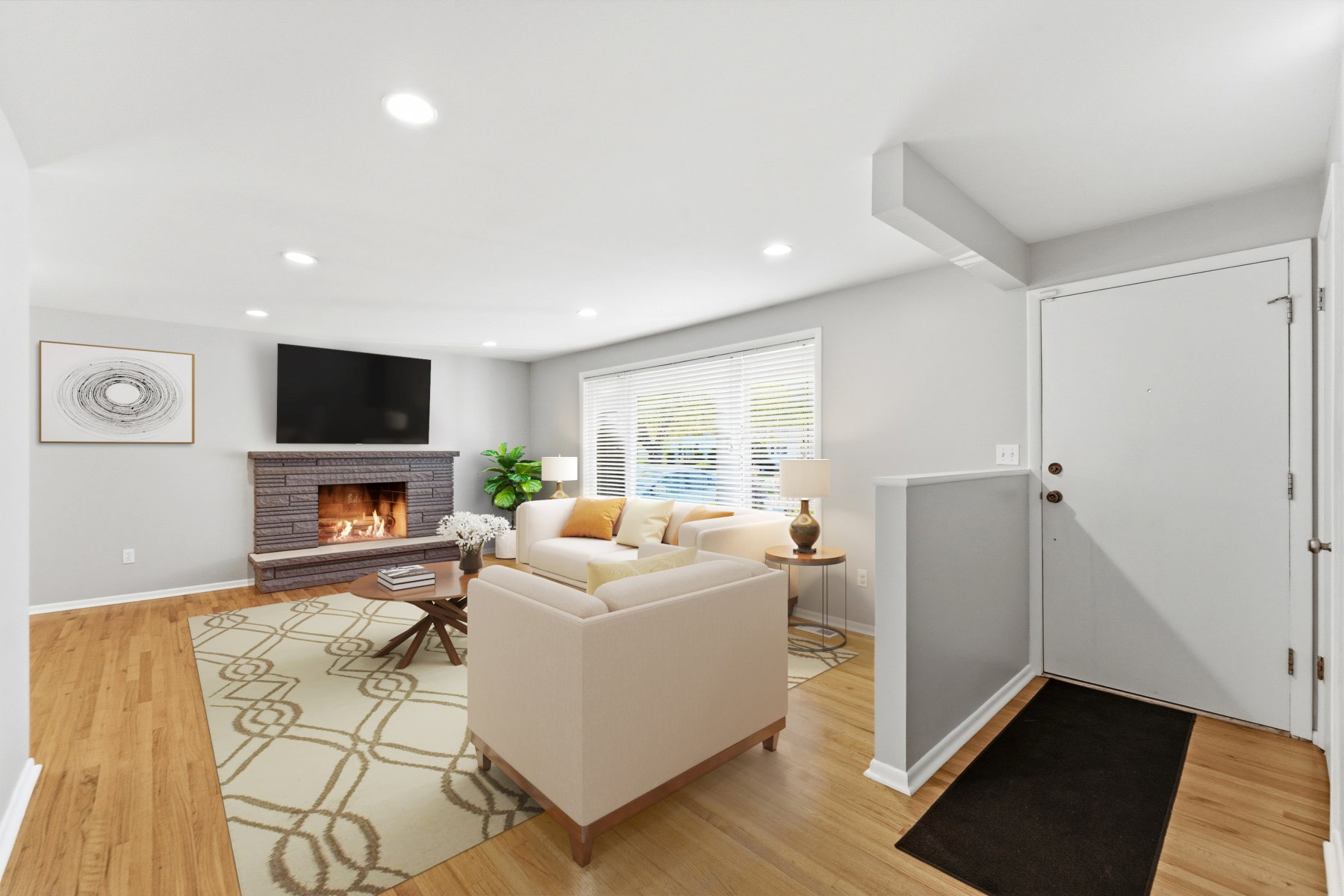 Living room featuring light wood-style flooring, a stone fireplace, and recessed lighting