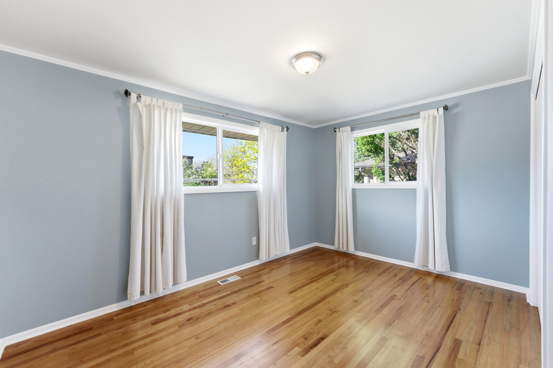 Unfurnished room featuring light wood-type flooring, crown molding, and healthy amount of natural light