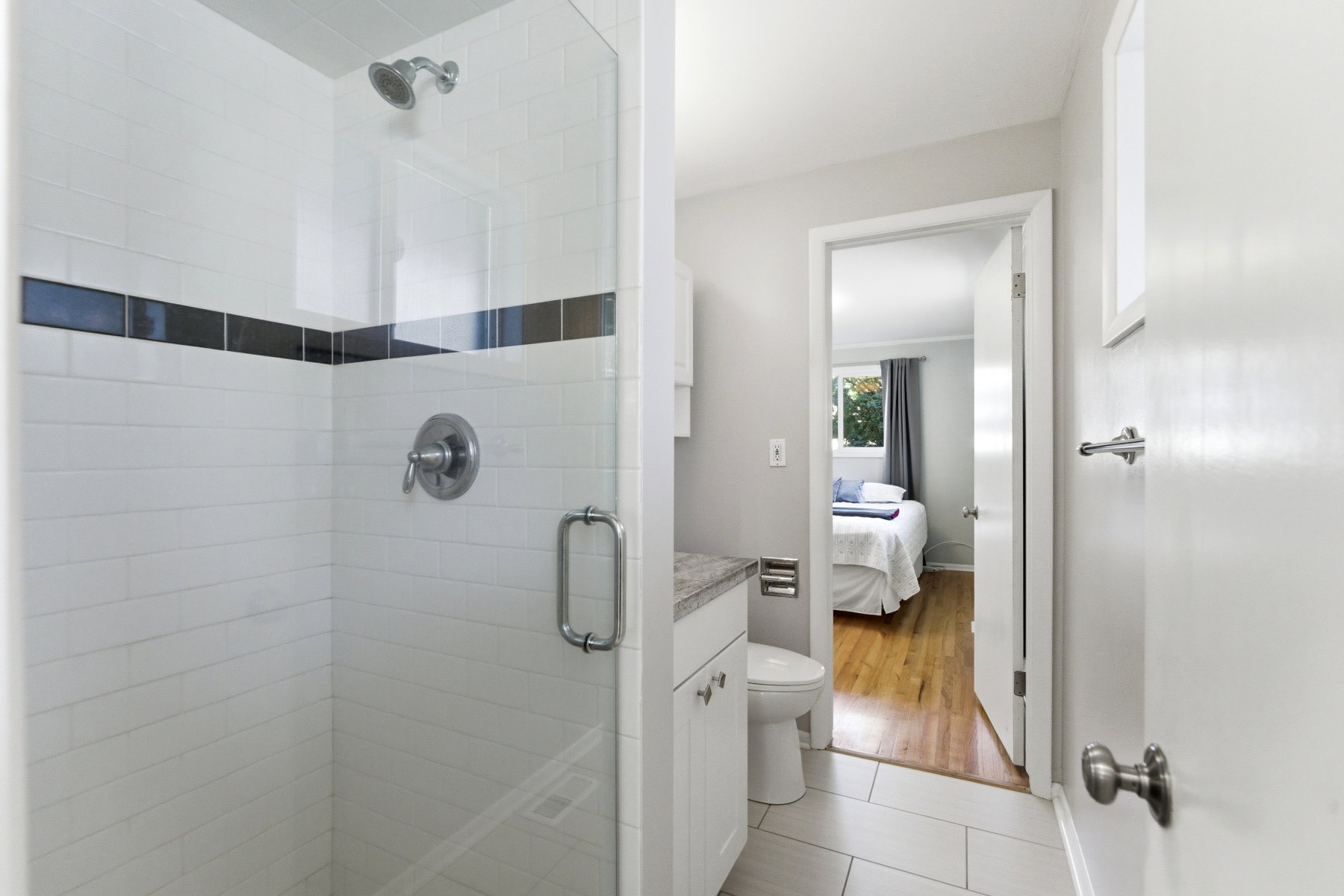 Ensuite bathroom featuring vanity, a shower stall, and light tile patterned floors