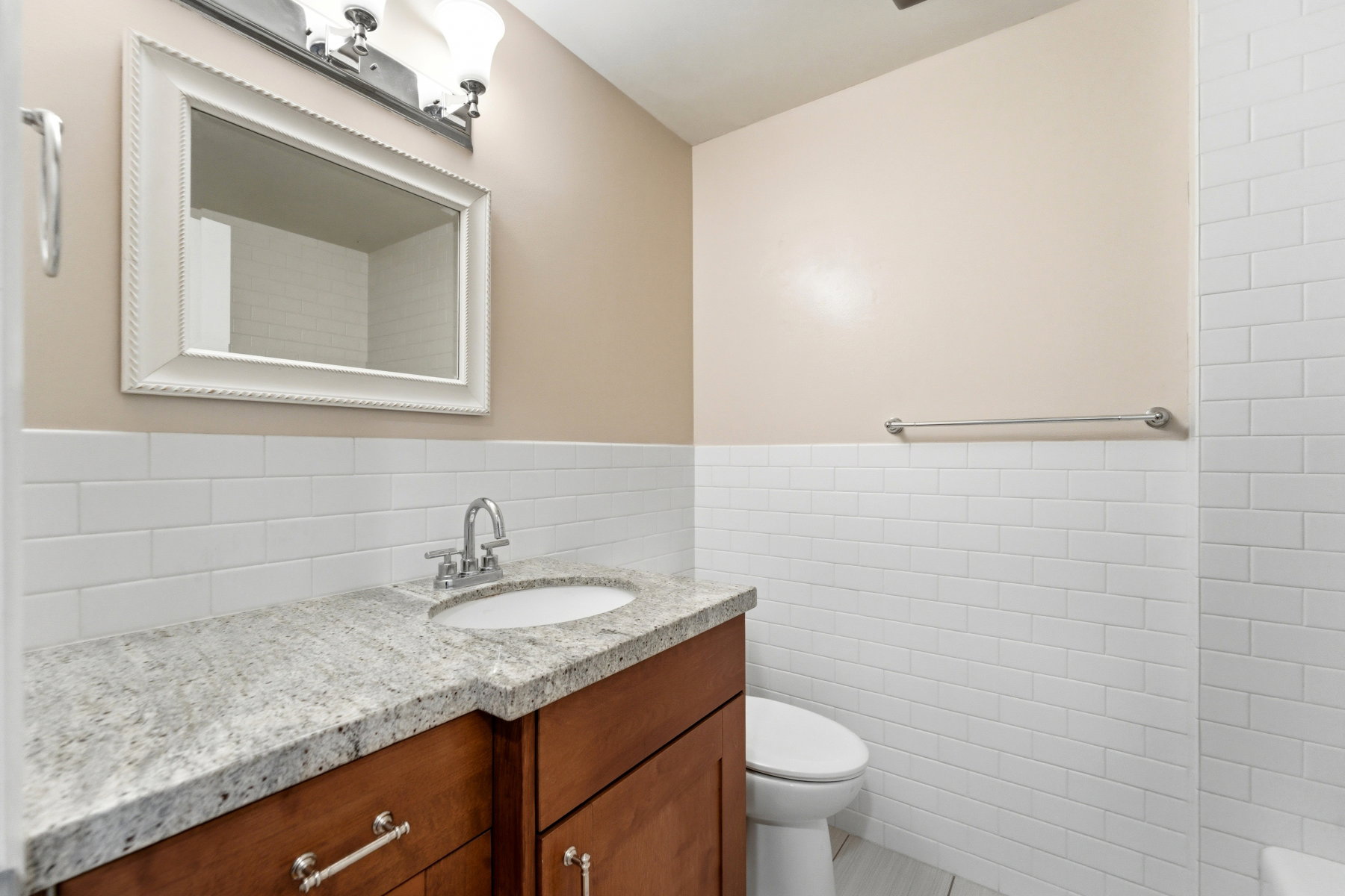 Bathroom featuring vanity, tile walls, and a wainscoted wall