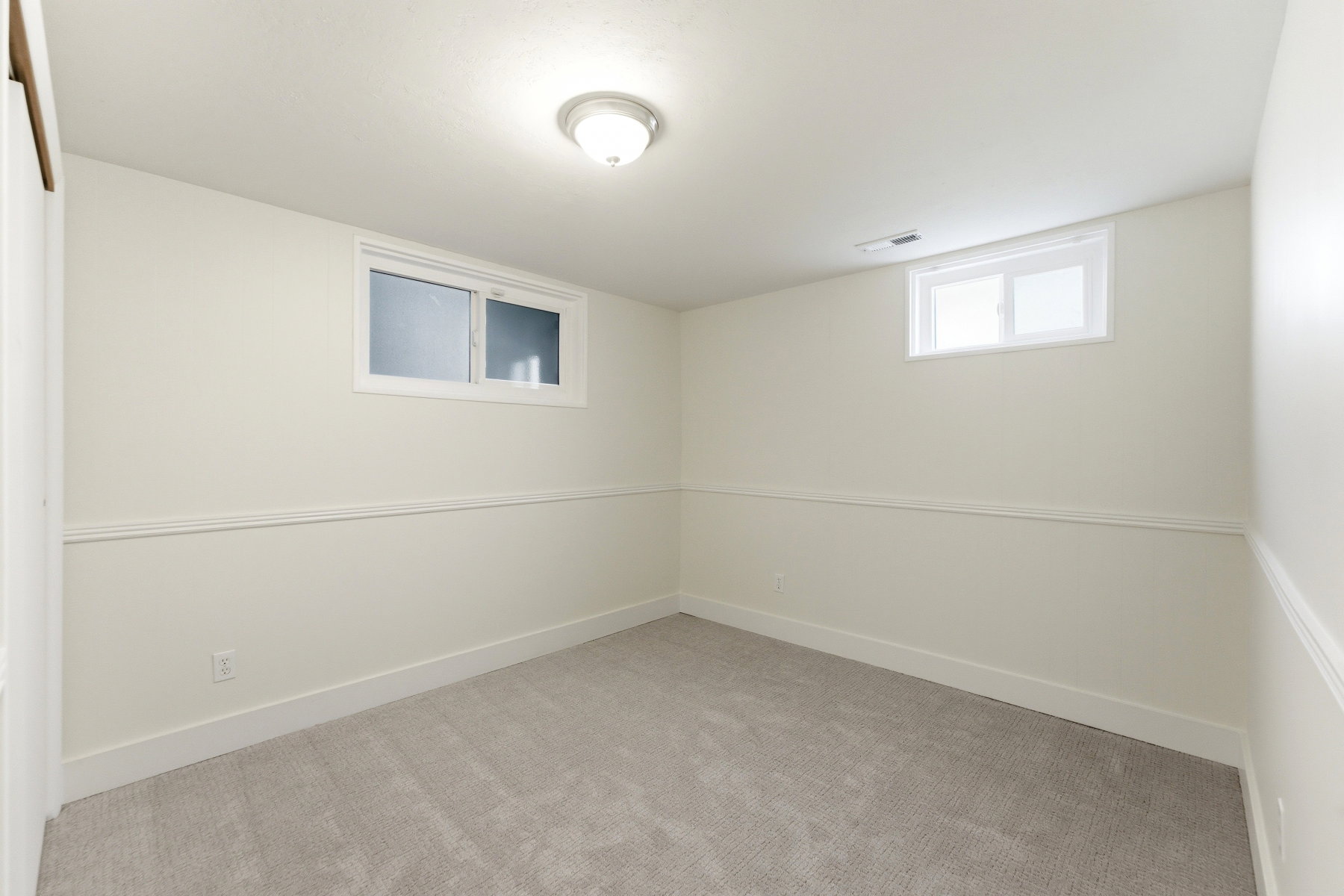 Below grade area featuring light colored carpet and baseboards