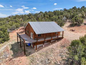 Back of property with a metal roof and covered porch