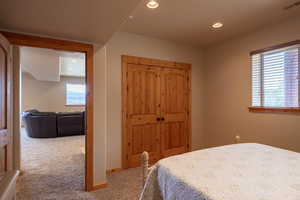 Bedroom with light carpet, a closet, and recessed lighting