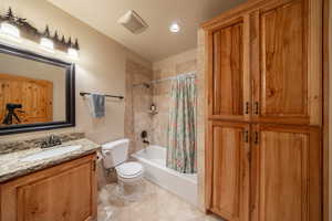 Full bath featuring vanity, shower / tub combo with curtain, and light tile patterned flooring