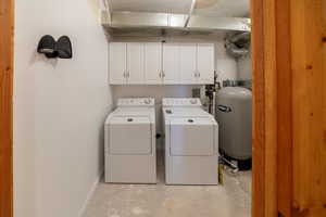 Laundry room featuring concrete flooring, cabinet space, and washing machine and dryer