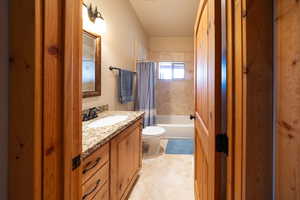 Bathroom with vanity, shower / tub combo, and light tile patterned floors