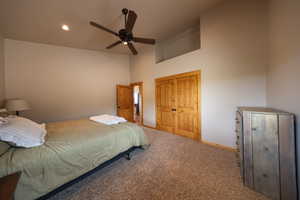 Bedroom featuring carpet, ceiling fan, a closet, a high ceiling, and recessed lighting